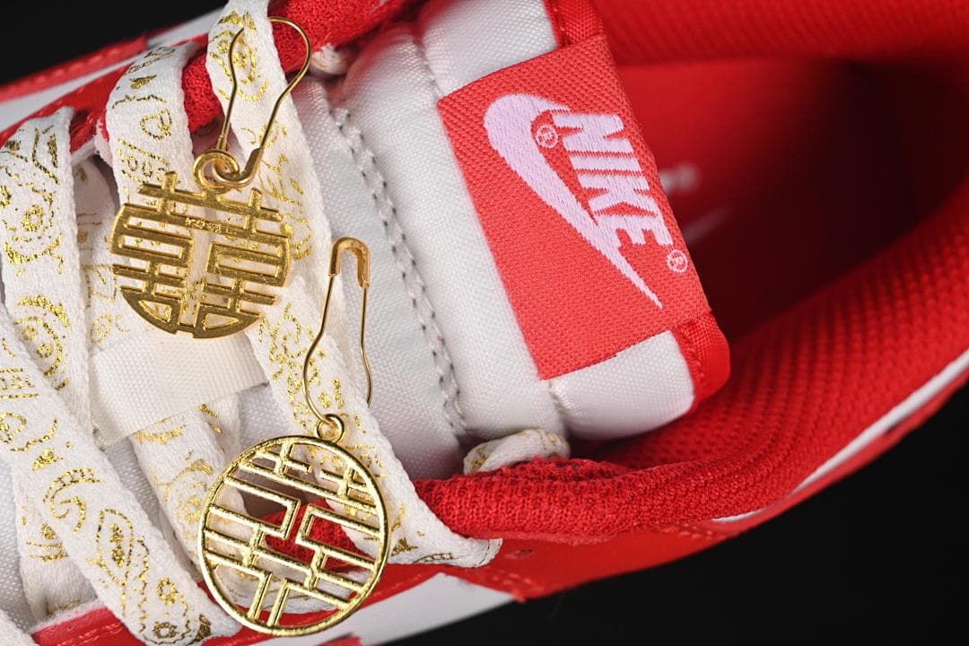 Close-up of the tongue, patterned laces, and gold-tone charms