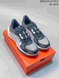 Pair of charcoal and gray Nike Zoom Plus sneakers with white accents on an orange shoe box