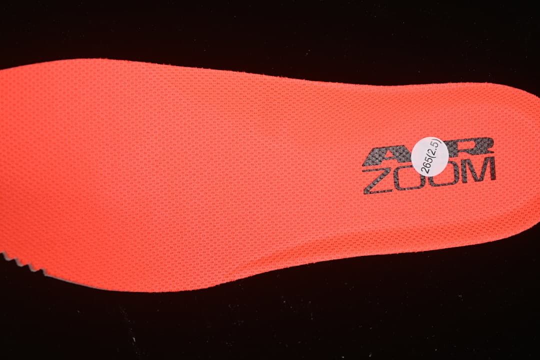 Bright red-orange shoe insole with Zoom branding.