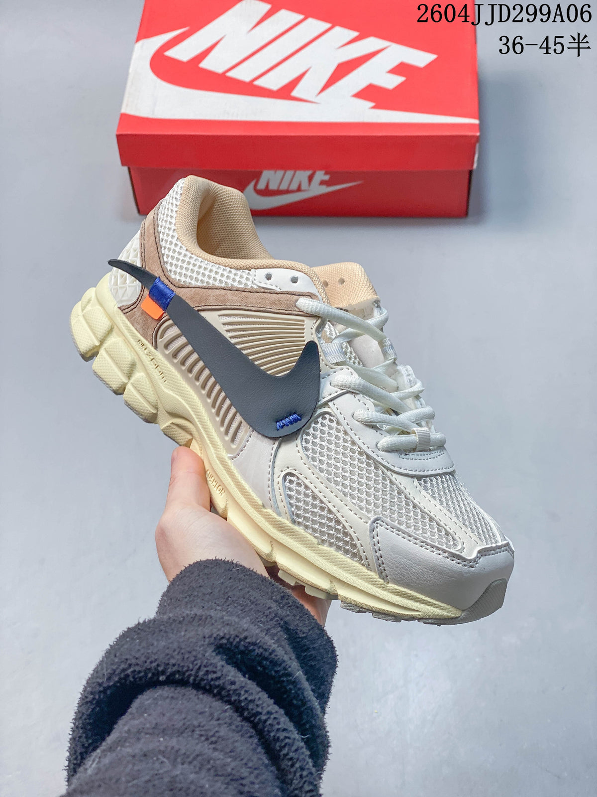 Angled side view of a Nike Zoom Vomero 5 sneaker with dark Swoosh accents and a sculpted light-colored sole.