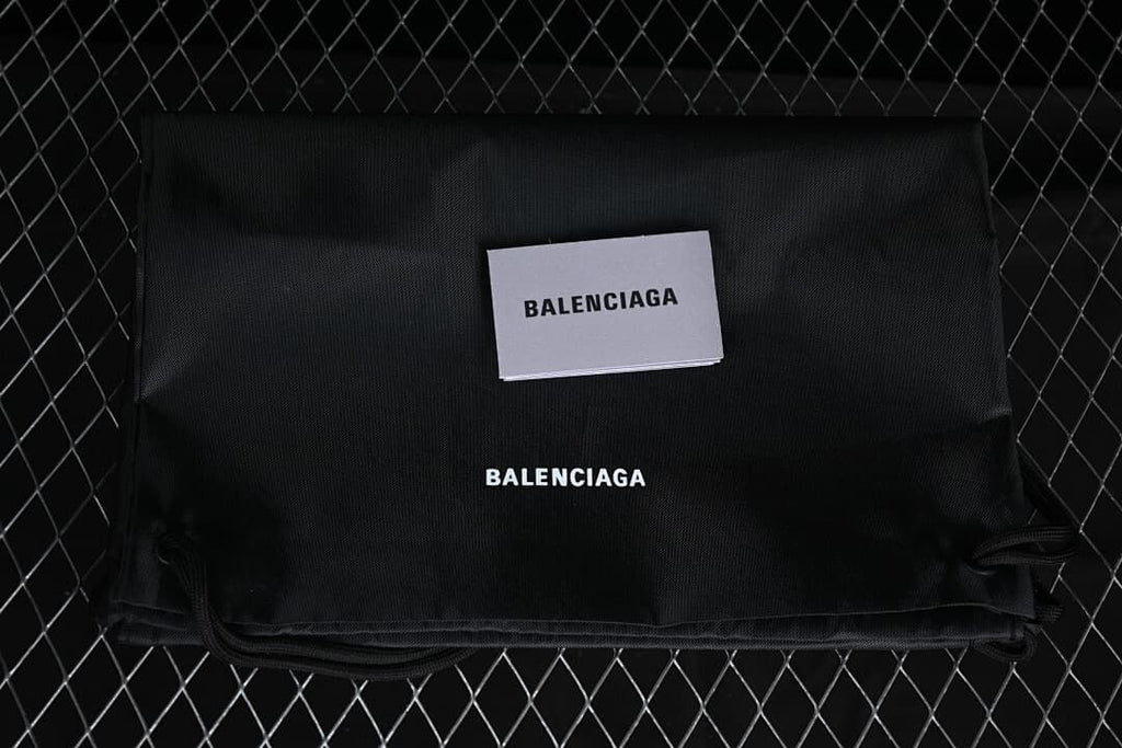 Black drawstring bag and card bearing Balenciaga branding.