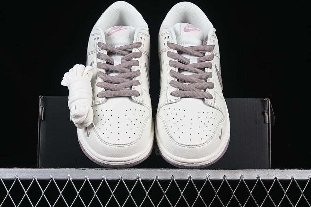 Front view of both sneakers with perforated toe boxes and an extra set of white laces