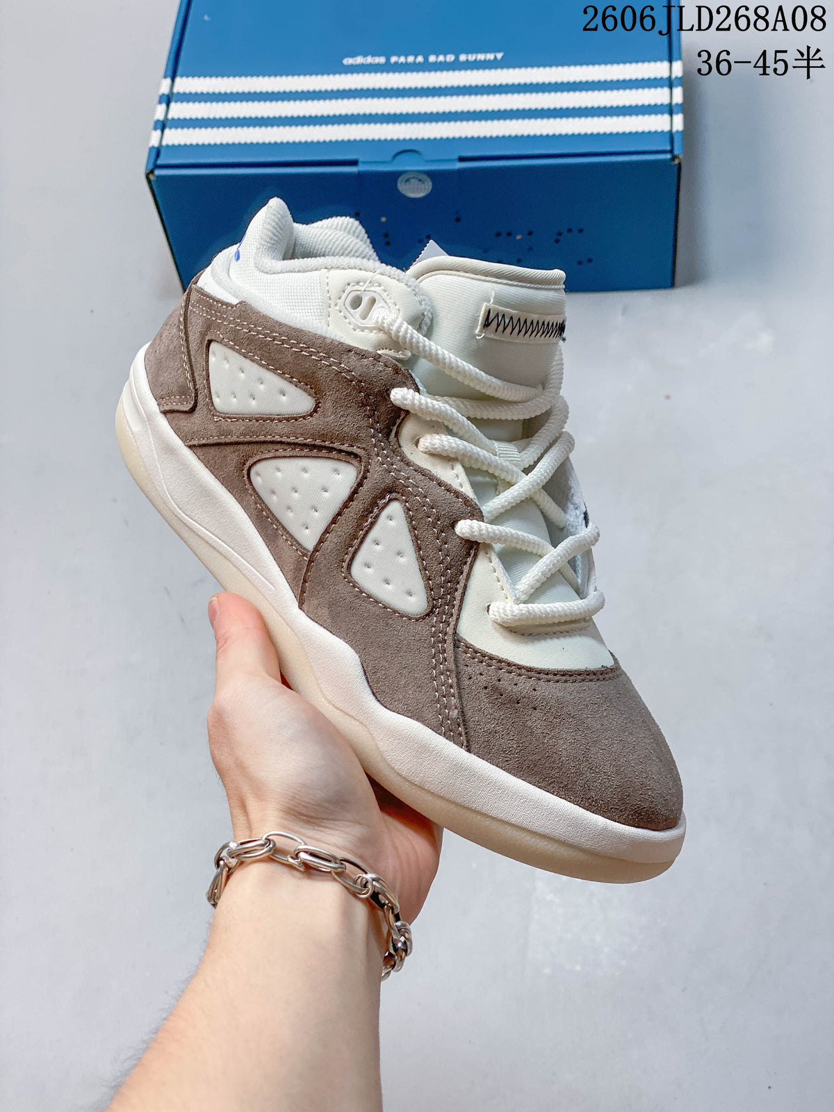 Angled side view of the taupe and cream sneaker