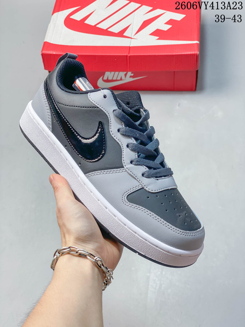 Angled side view of a gray and black NikeCourt Borough 2 sneaker