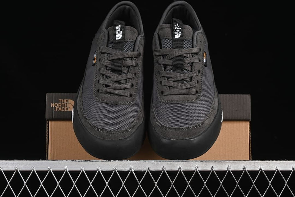 Front view of the pair of lace-up sneakers on a shoebox