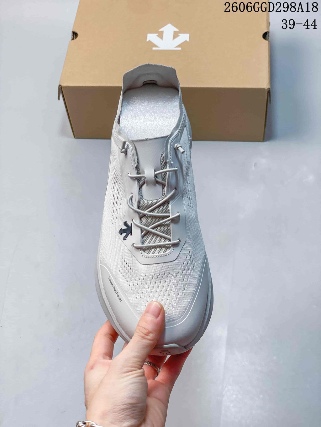 Top view of the light gray sneaker showing its perforated upper and lace-style closure.