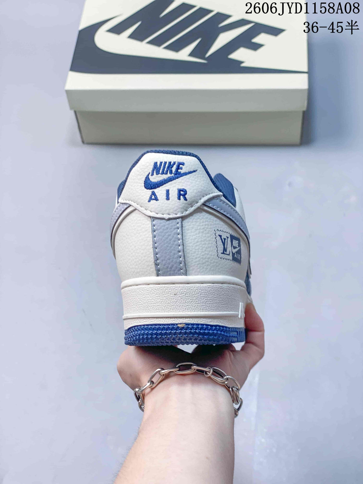 Rear view of a white and blue low-top sneaker with Nike Air heel branding