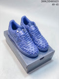 Pair of blue Nike Air Force 1 low-top sneakers with raised star details, displayed on a shoe box