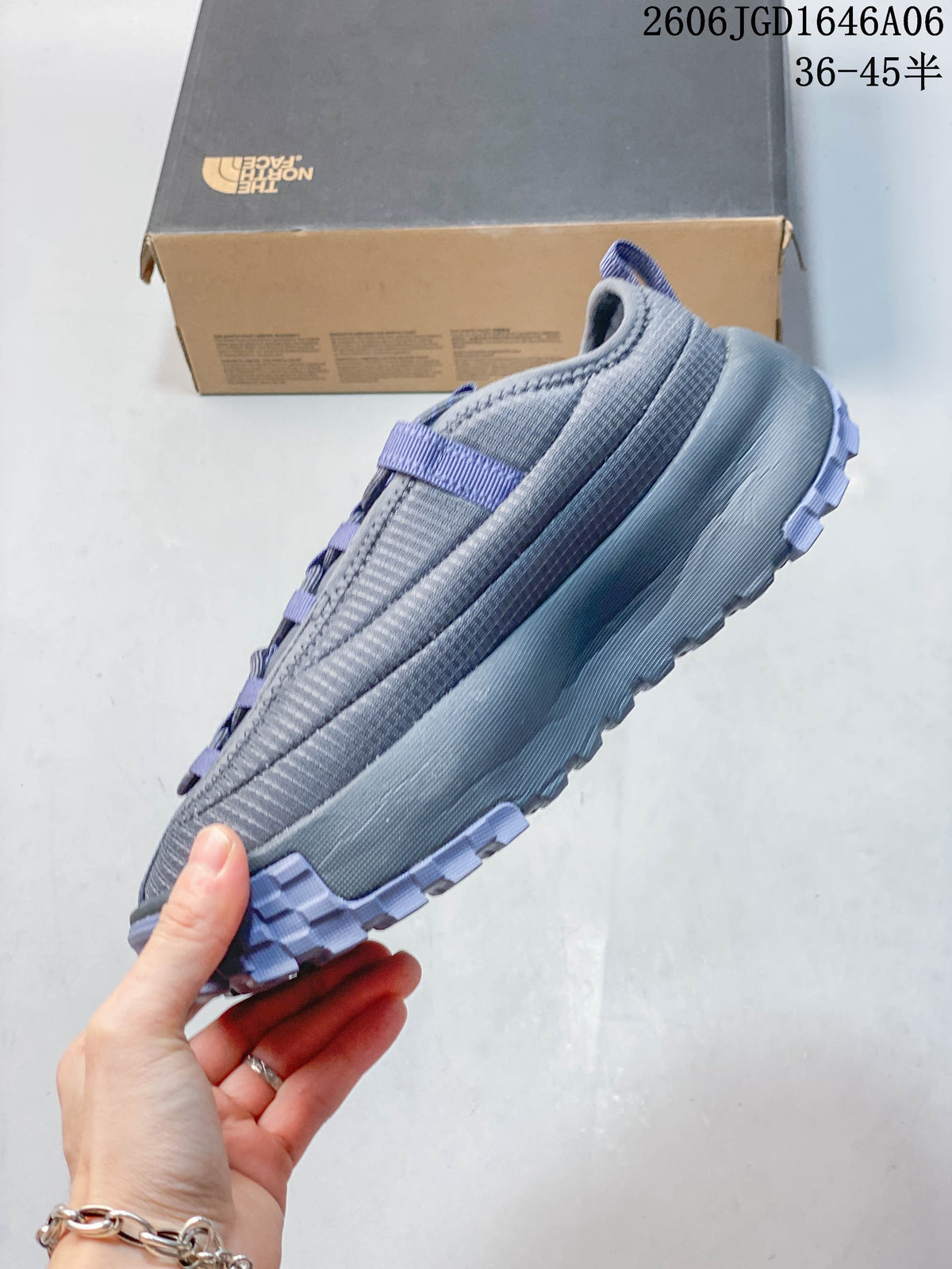 Side view of the gray mule shoe with lavender details and a thick sole
