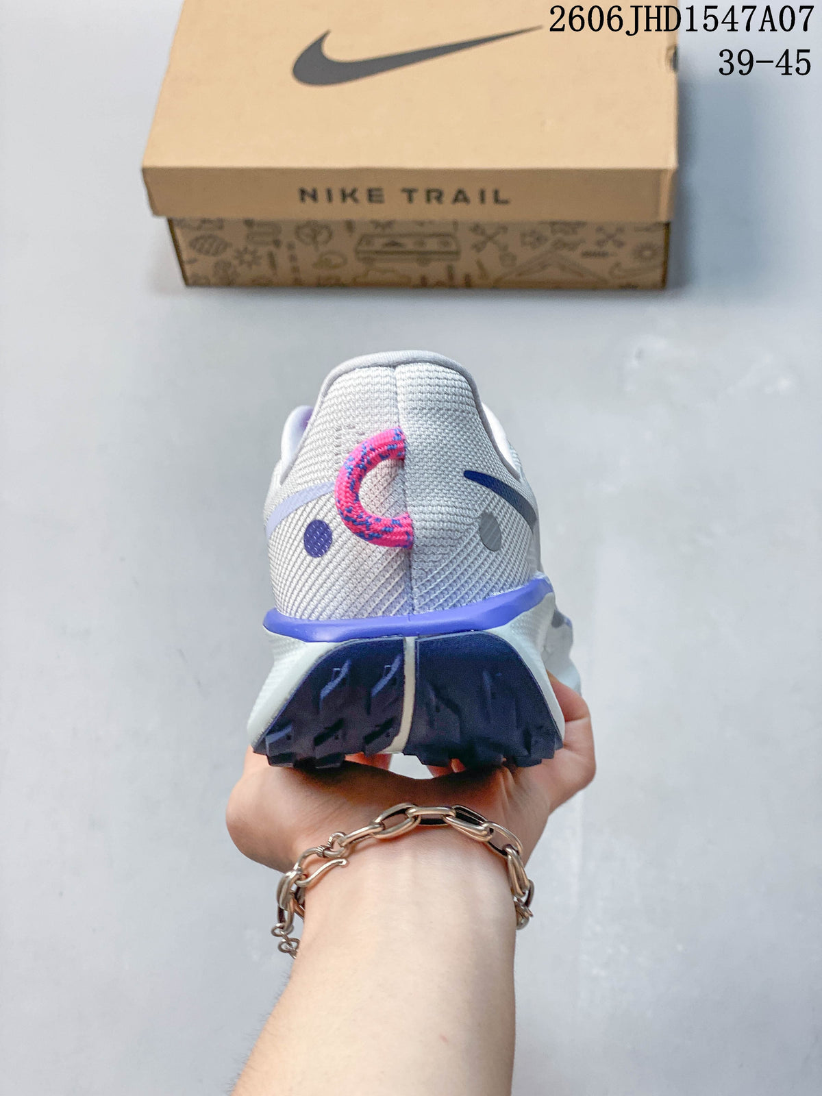 Rear view of a gray Nike ReactX Pegasus Trail 5 shoe with a patterned pink pull tab and lugged outsole.