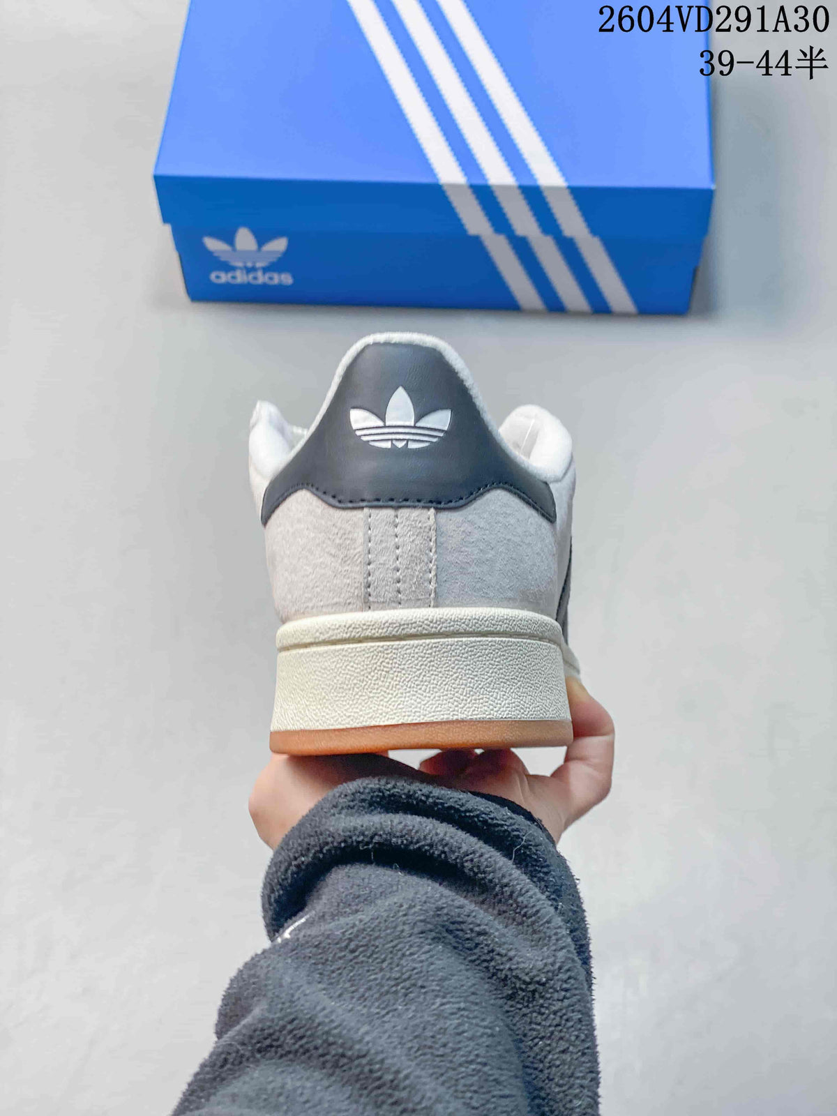 Rear view of the light gray sneaker showing the dark heel panel and off-white midsole.