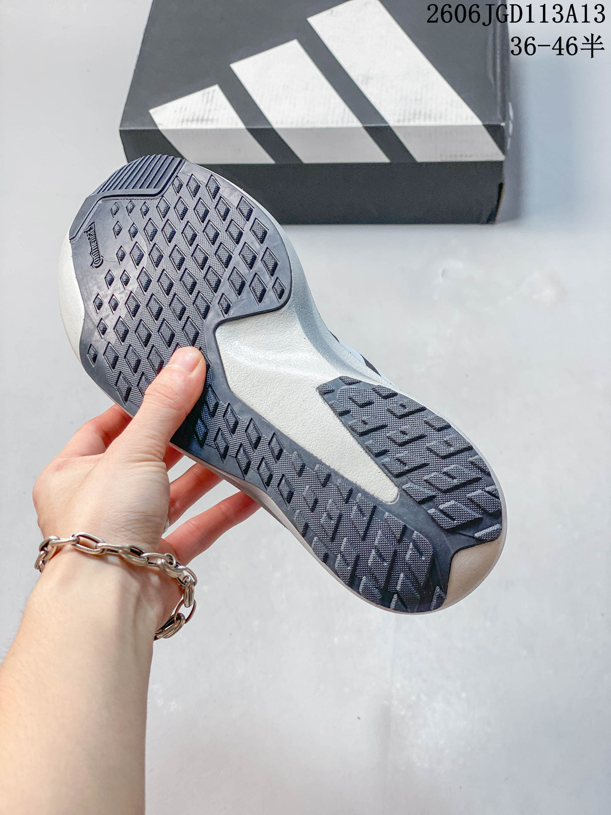 Close-up of the patterned outsole on a charcoal gray Adizero Evo SL ATR shoe.
