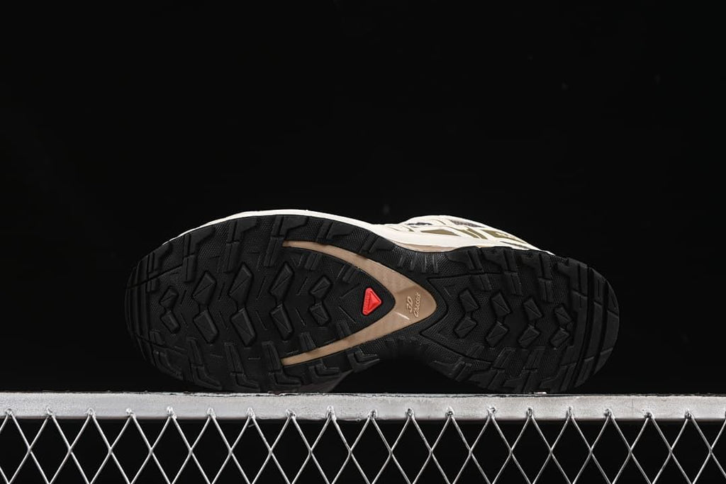Underside view showing the lugged outsole and red center emblem.