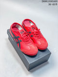 Red and dark-accented Onitsuka Tiger Mexico 66 Deluxe sneakers shown on a shoebox