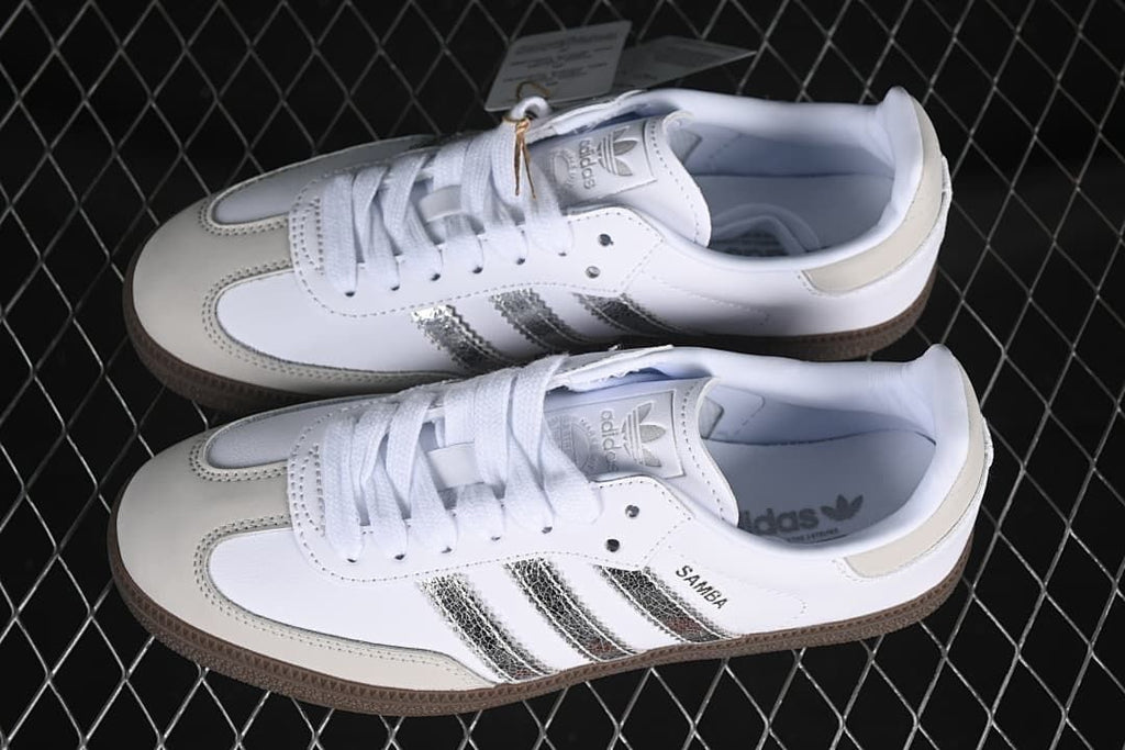 Pair of white Samba OG sneakers with silver stripes and brown soles