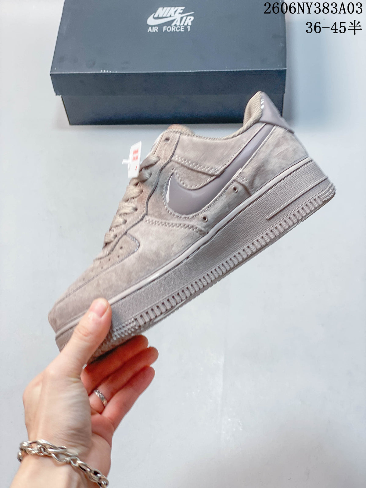 Side profile of a taupe low-top sneaker with a Swoosh detail