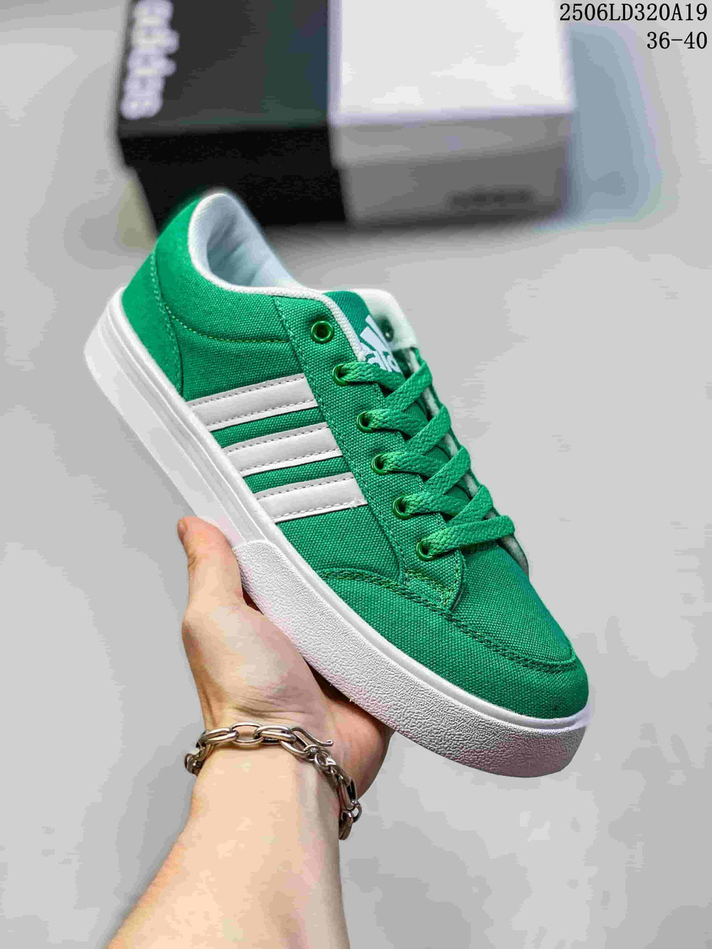 Angled view of a green low-top sneaker with white stripes and white sole