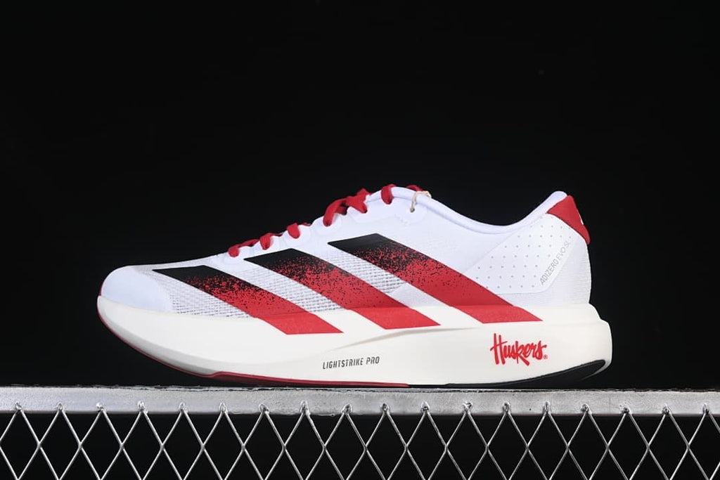 Side profile of the shoe with Nebraska graphics and red-black stripes
