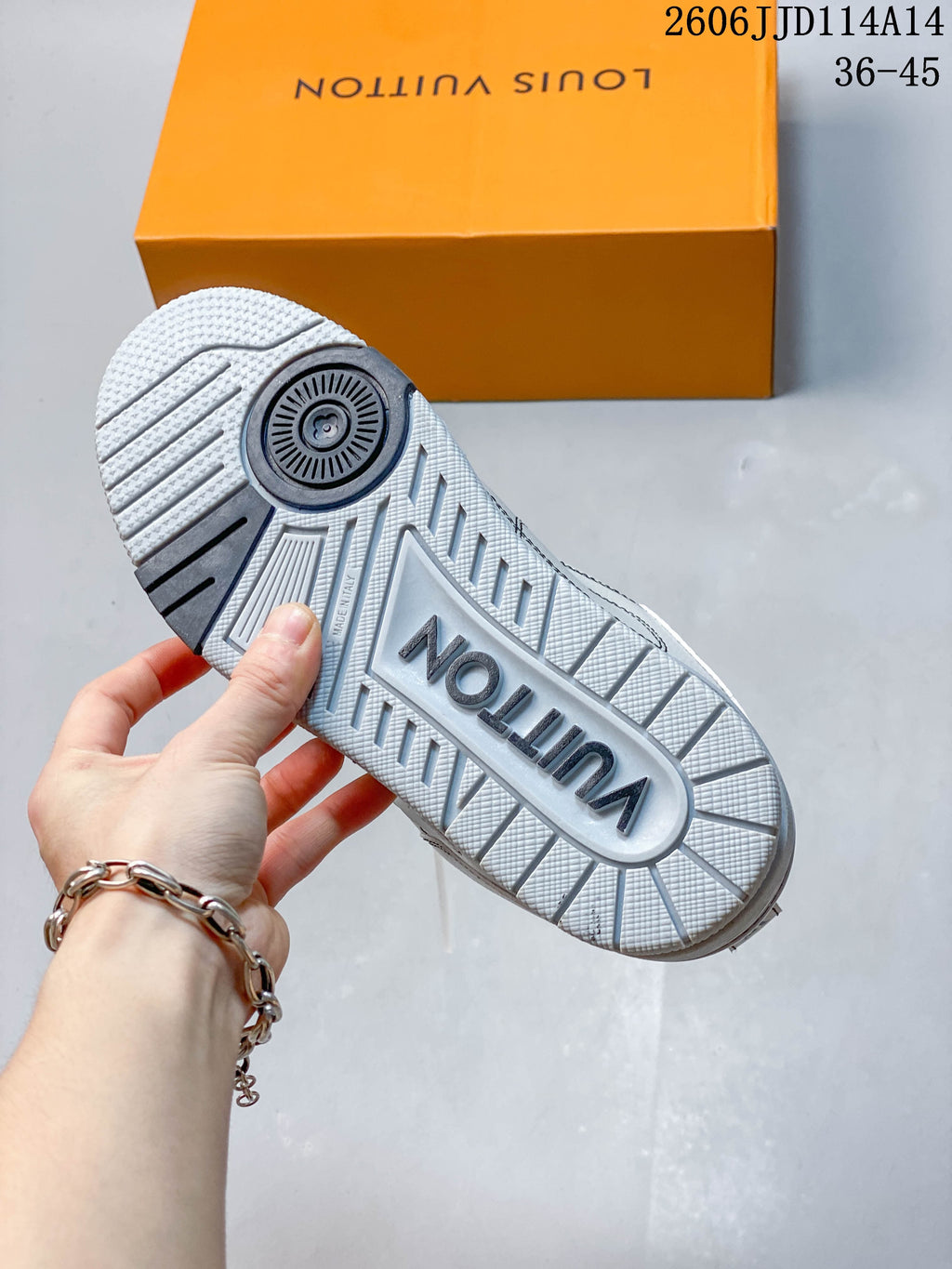 Outsole of a white and gray Trainer sneaker with a large central logo.