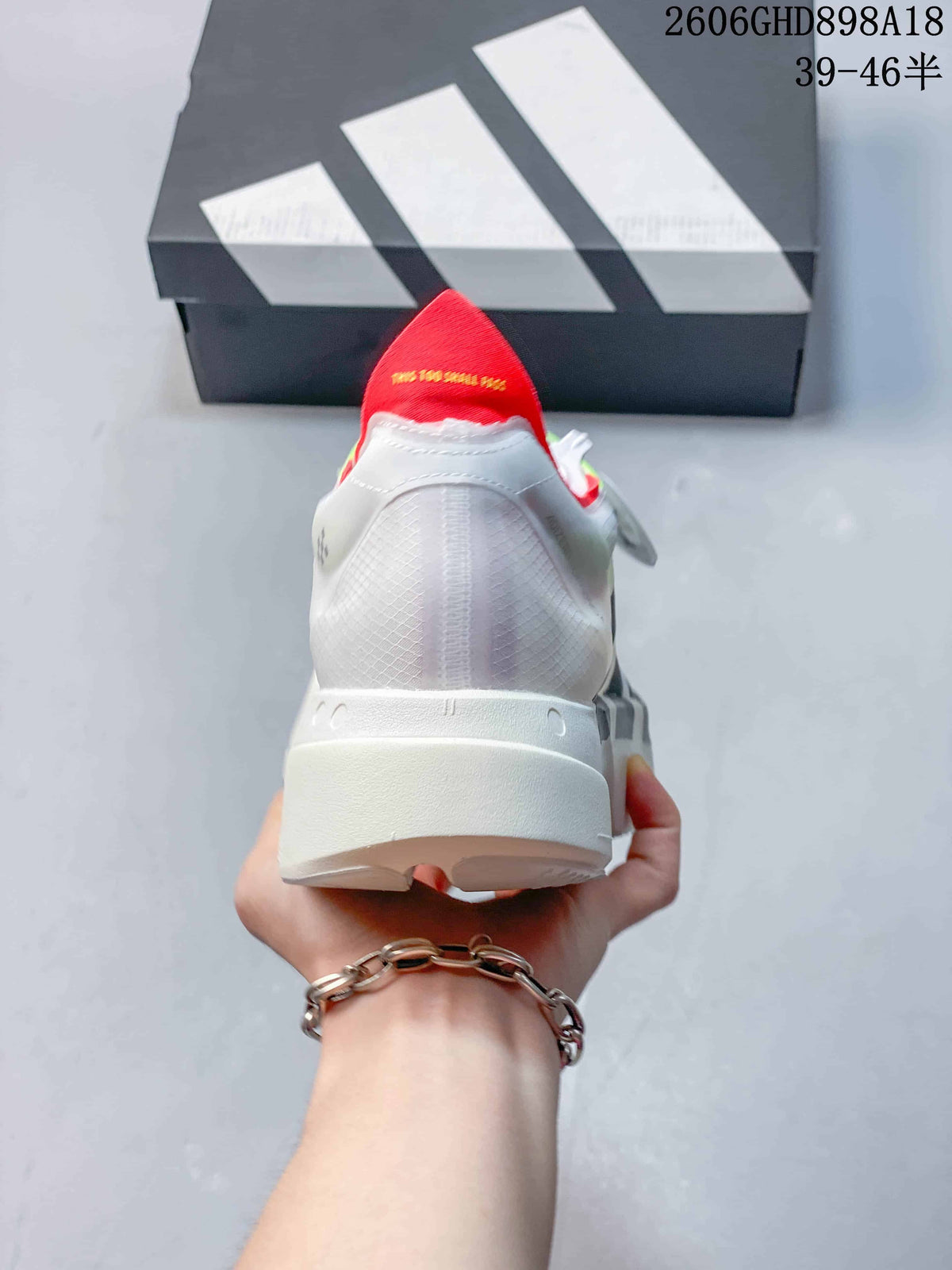 Rear view of the white running shoe showing its heel and red pull tab.