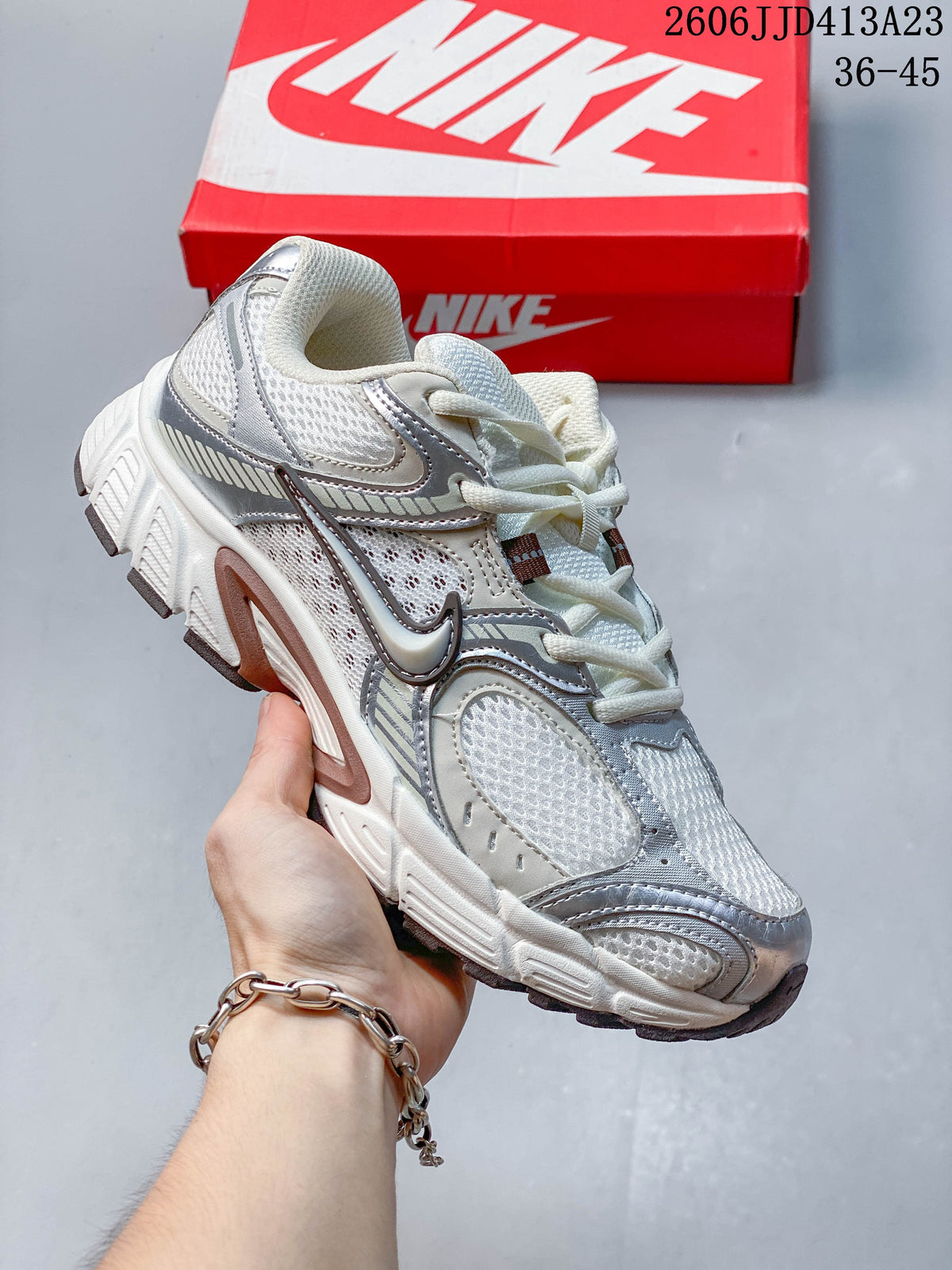 White and silver Nike Air Zoom Winflo 12 sneaker shown with a red shoe box.