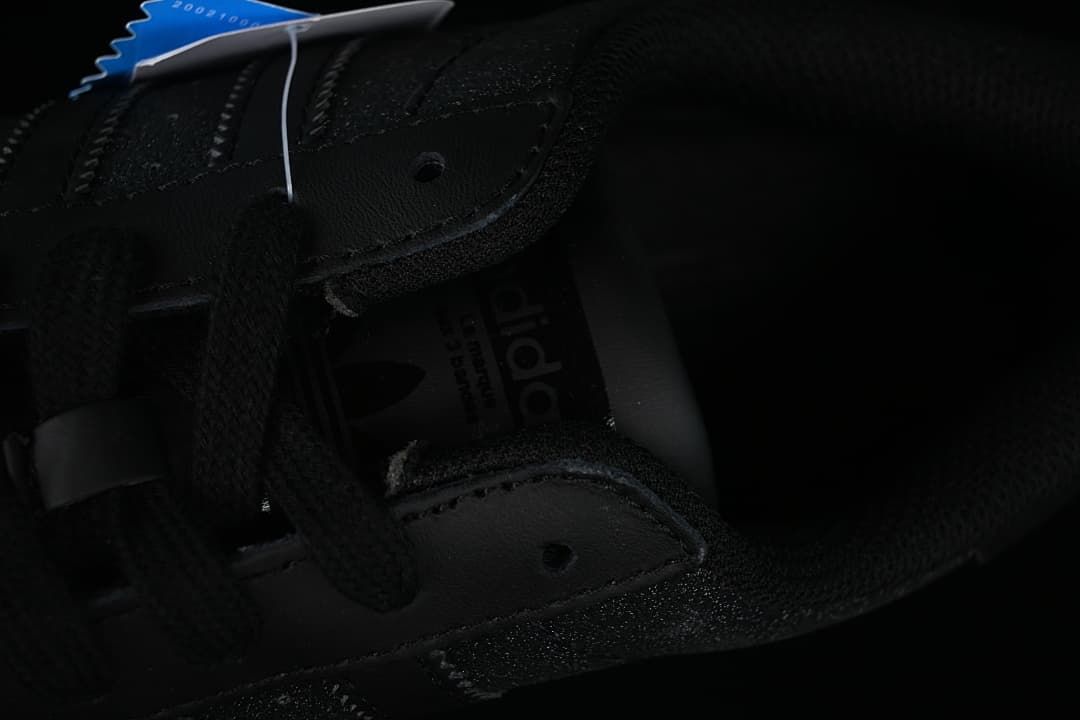 Close view of the black laces, eyelets, and tongue branding