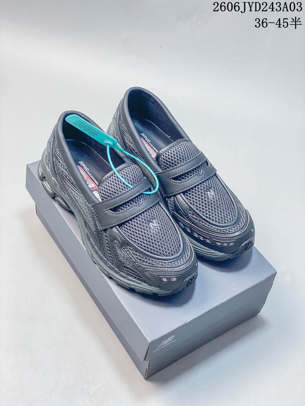 Pair of charcoal gray New Balance 1906L loafer-style sneakers shown from above at an angle