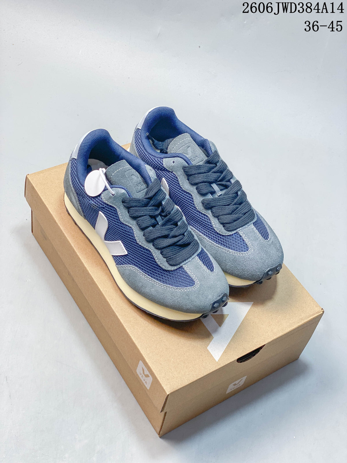 Pair of navy and grey Veja-branded low-top sneakers on a shoebox