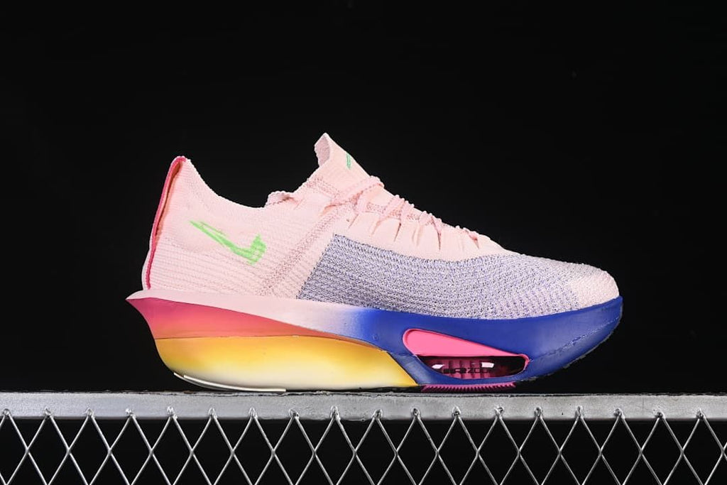 Side view of a shoe with pink upper, lavender-toned forefoot panel, green accents, and gradient sole