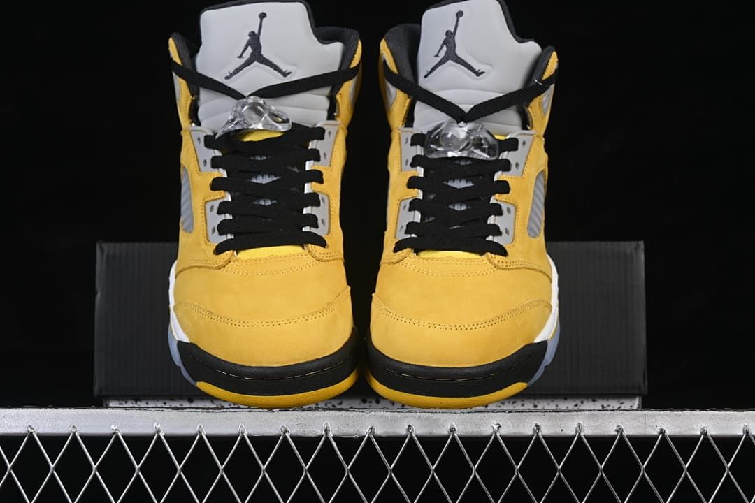 Front view of the pair showing yellow uppers, black laces, and grey tongues