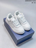 Pair of white Dior low-top sneakers showing perforated toe panels and patterned side panels