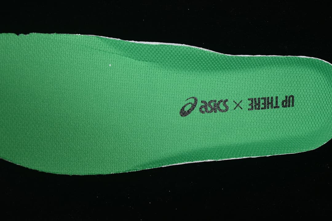 Green insole with ASICS and Up There markings.
