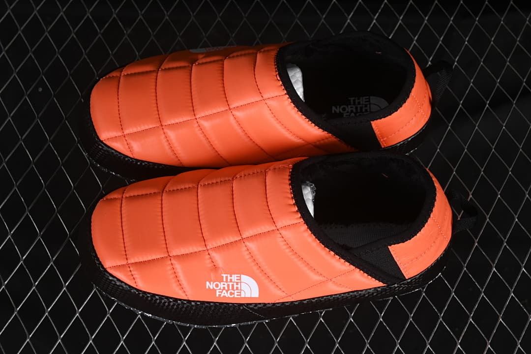 Pair of orange and black slip-on mules viewed from above