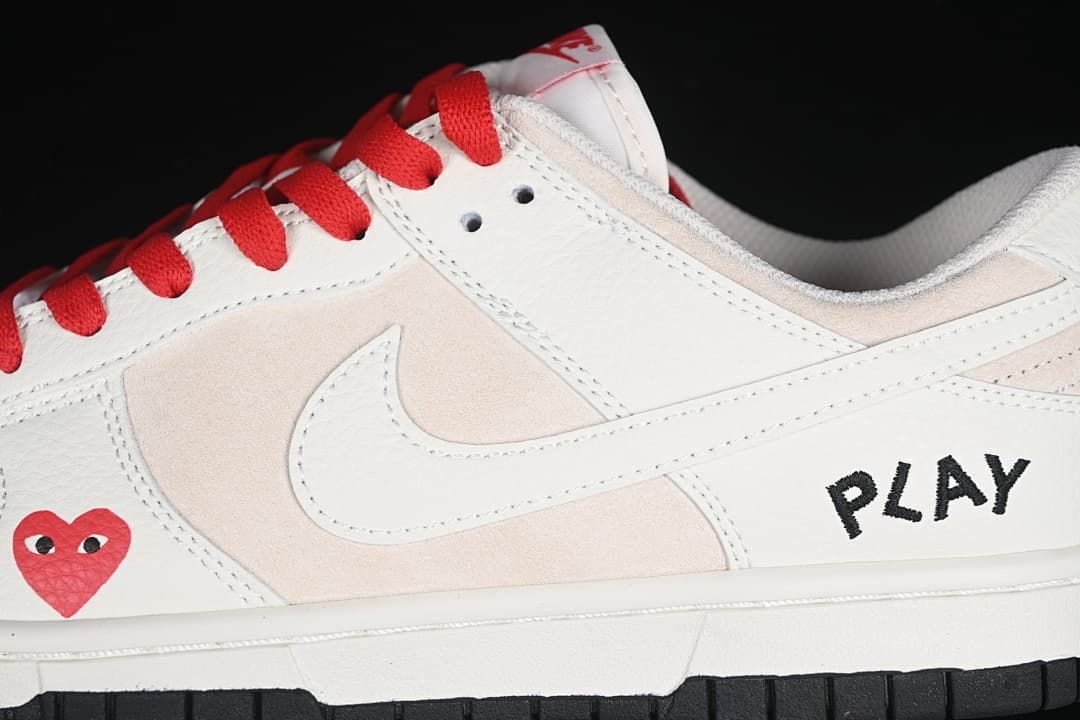 Close-up of the side swoosh, heart graphic, red laces, and PLAY lettering