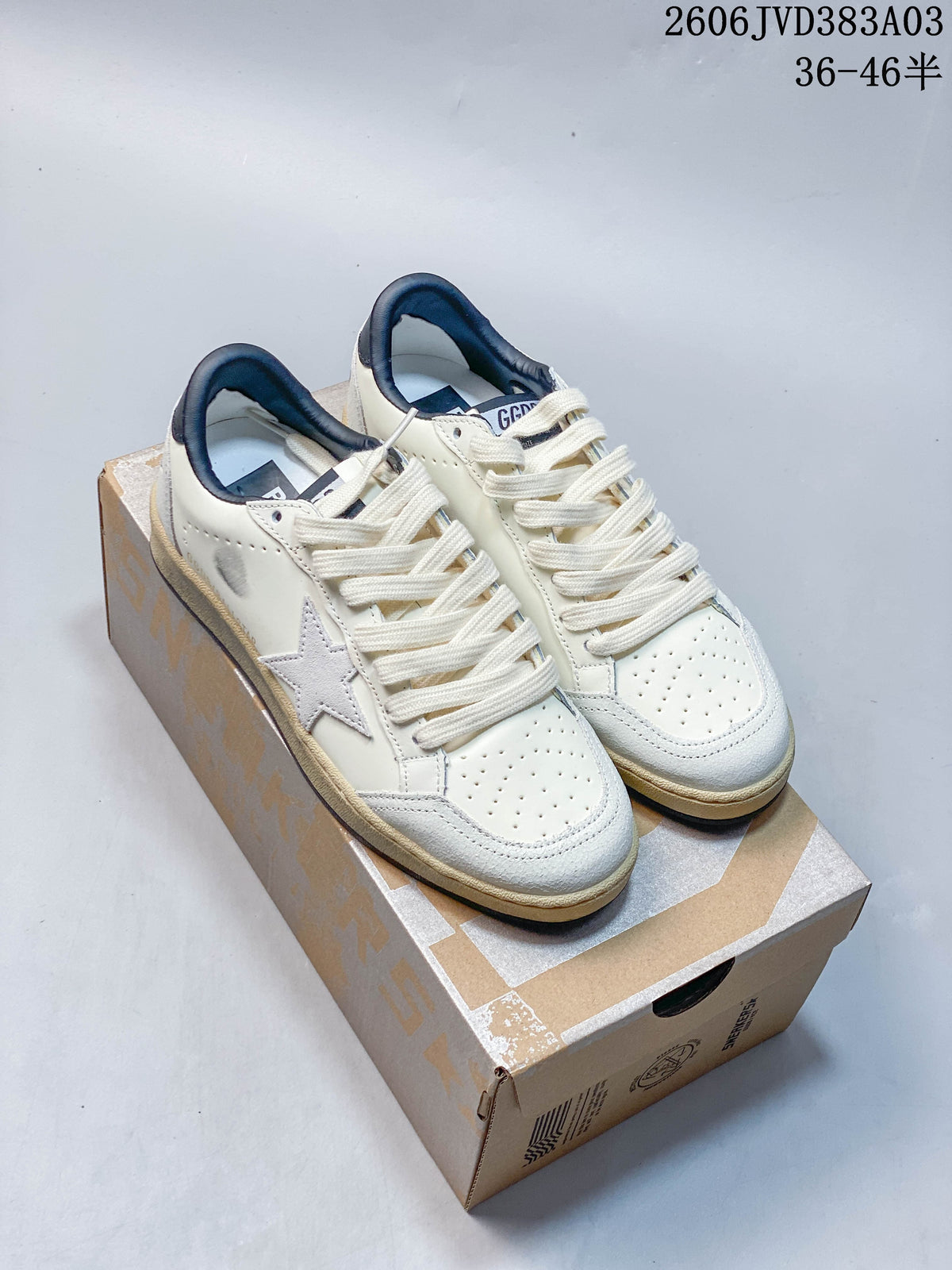 Pair of off-white Golden Goose Super-Star low-top sneakers with navy details displayed on a box