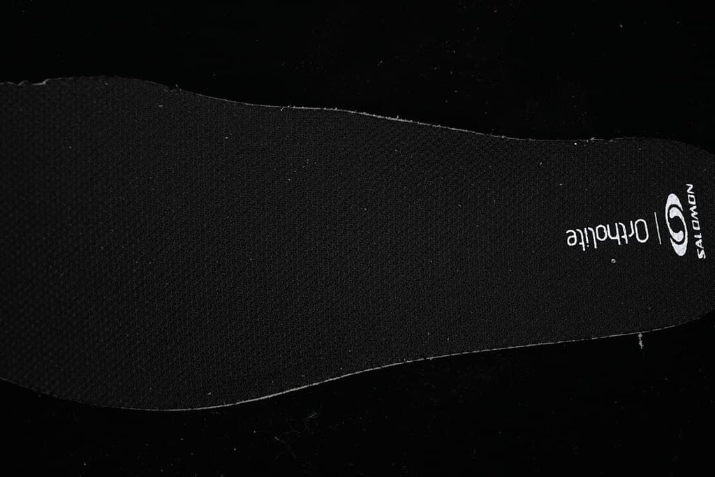 Black insole with Salomon and Ortholite markings.