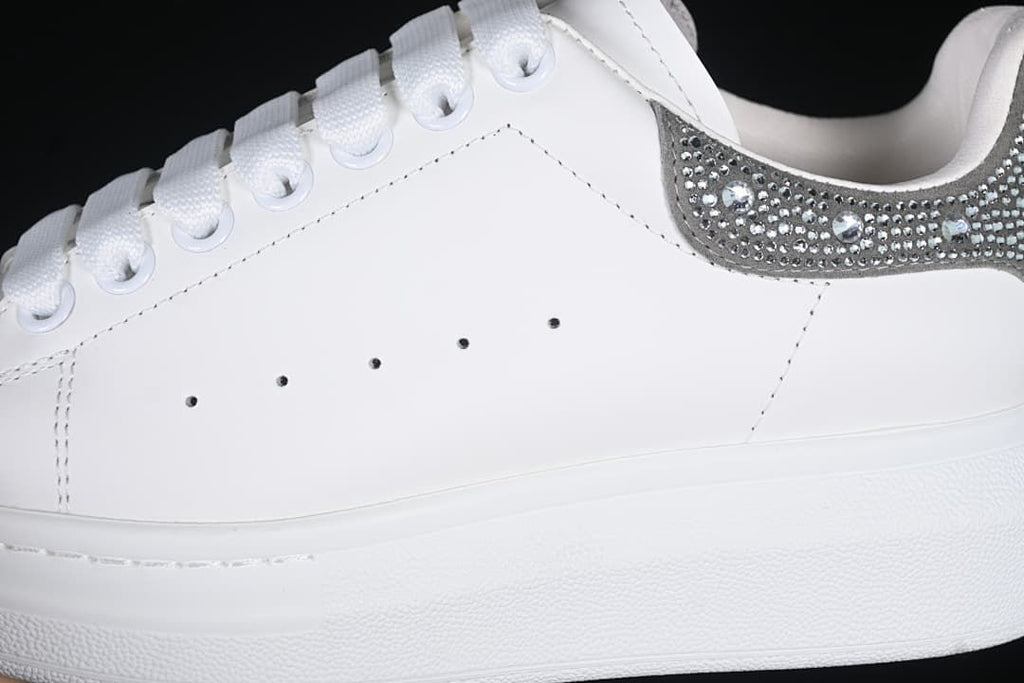 Close-up of the perforated white side panel, lace eyelets and embellished heel panel.