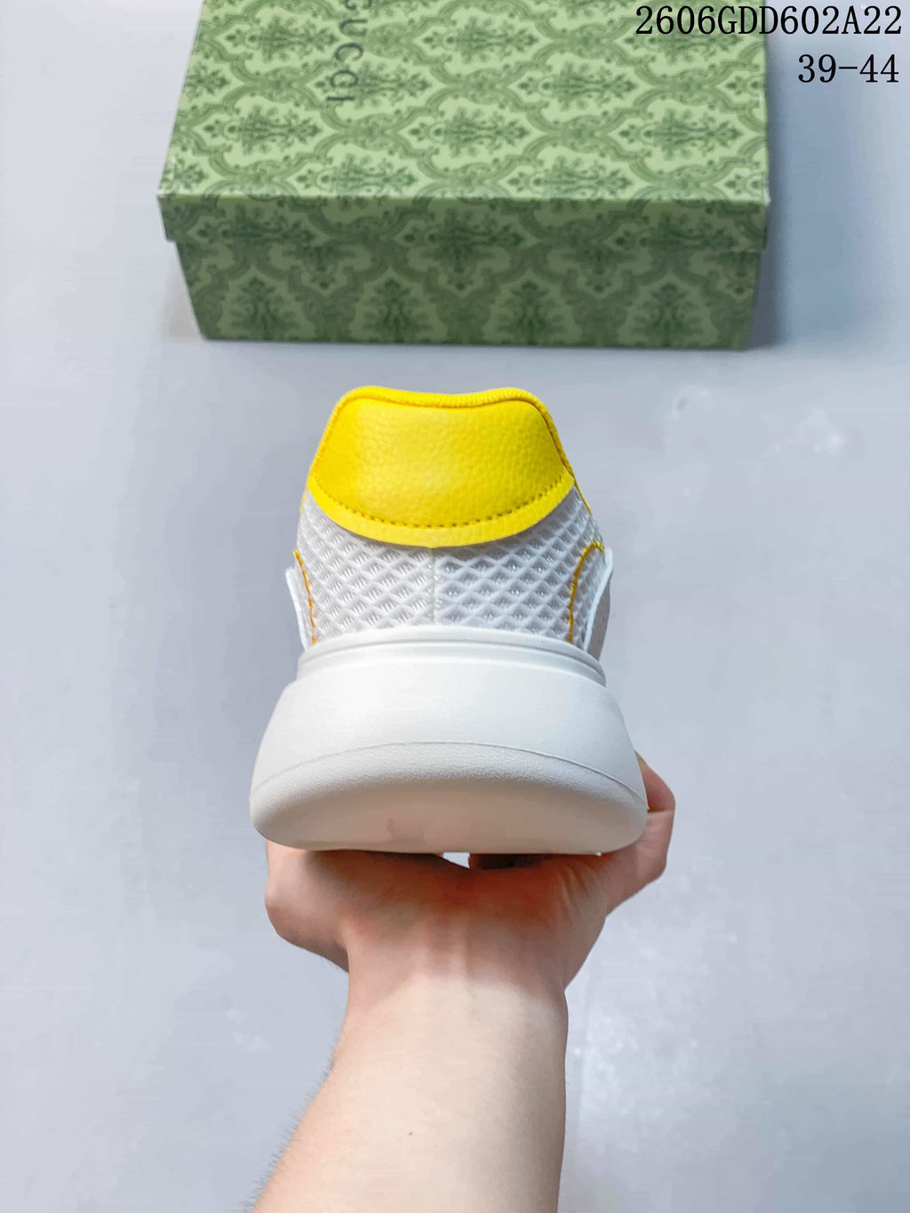 Rear view of the sneaker with a yellow collar and thick white sole