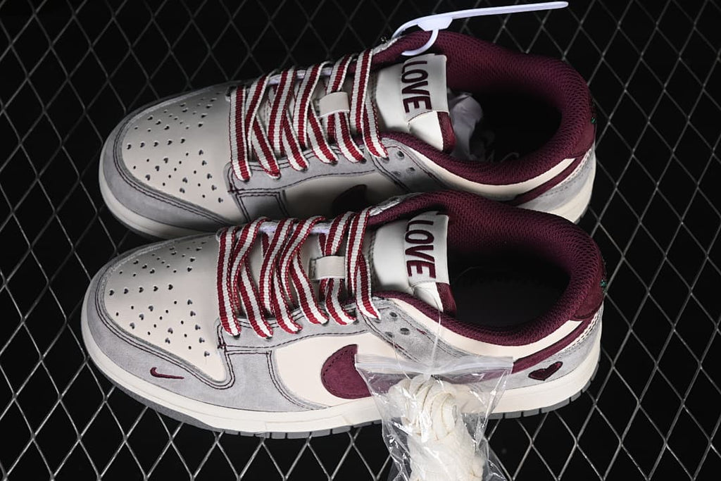 Pair of gray and off-white low-top sneakers with burgundy collars, striped laces, and heart details