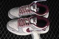 Pair of gray and off-white low-top sneakers with burgundy collars, striped laces, and heart details