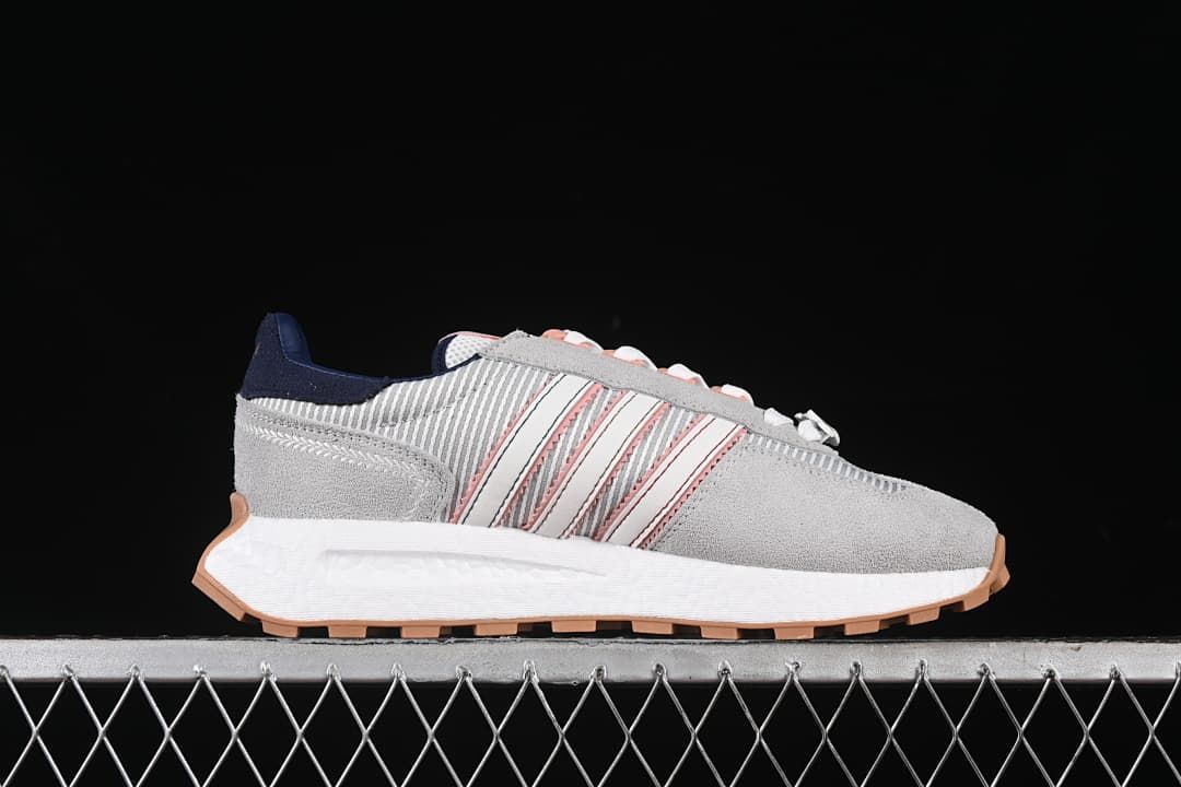 Side profile showing gray panels, pink-accented stripes, white midsole, and gum outsole