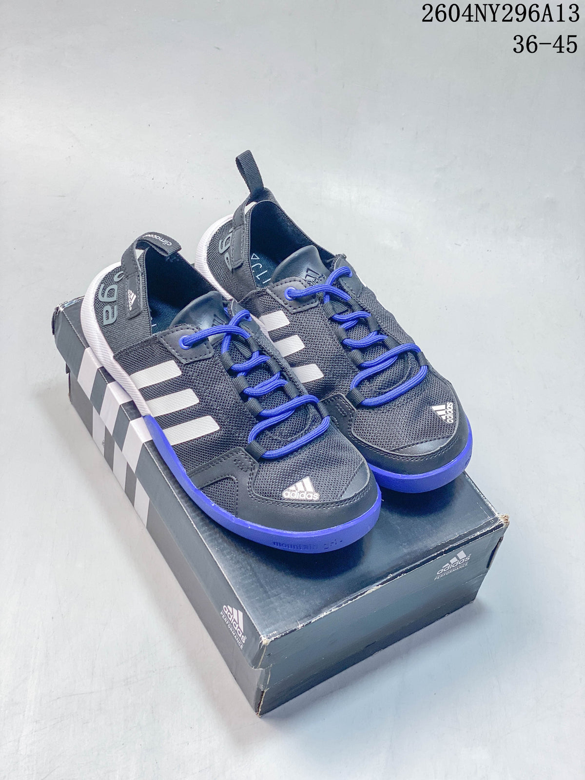 Pair of dark gray adidas TERREX shoes with bright blue laces and blue outsole accents.