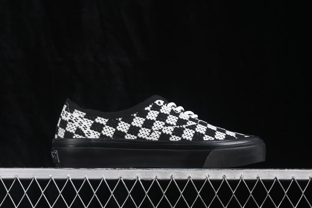 Opposite side profile showing the checkerboard upper, white laces and black rubber sole.