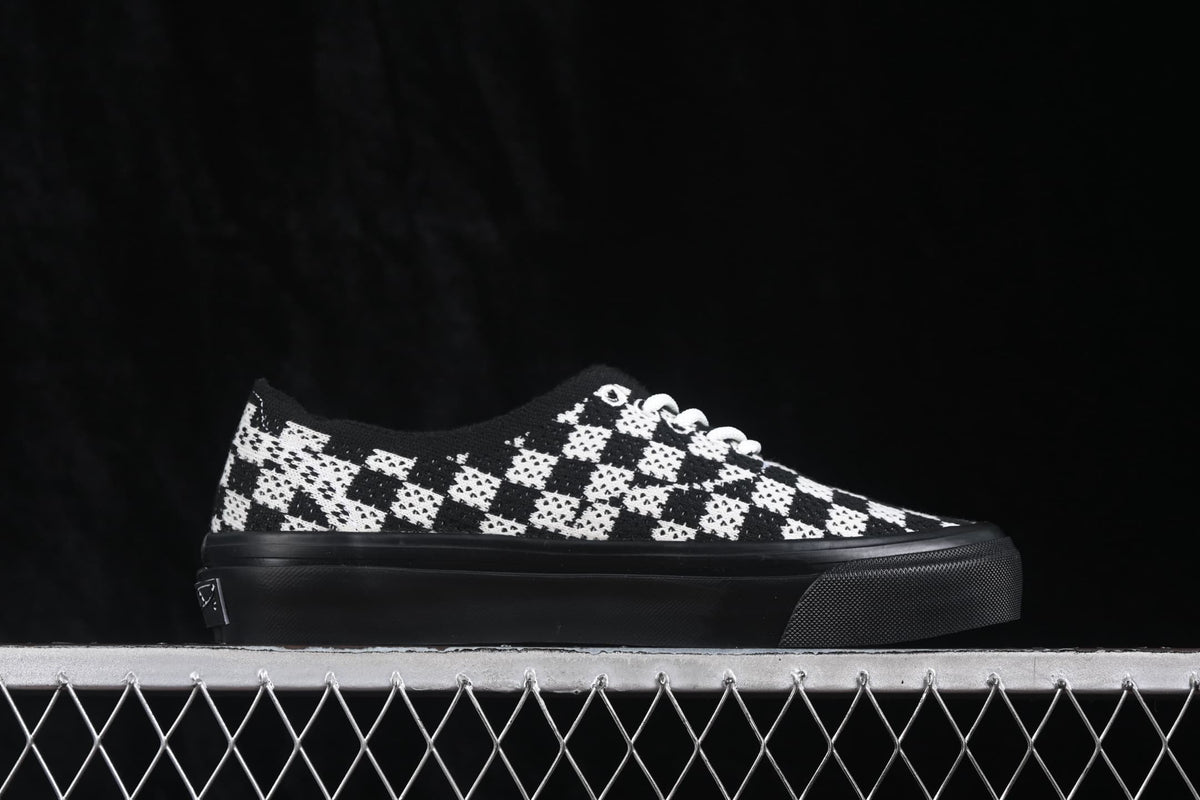 Opposite side profile showing the checkerboard upper, white laces and black rubber sole.