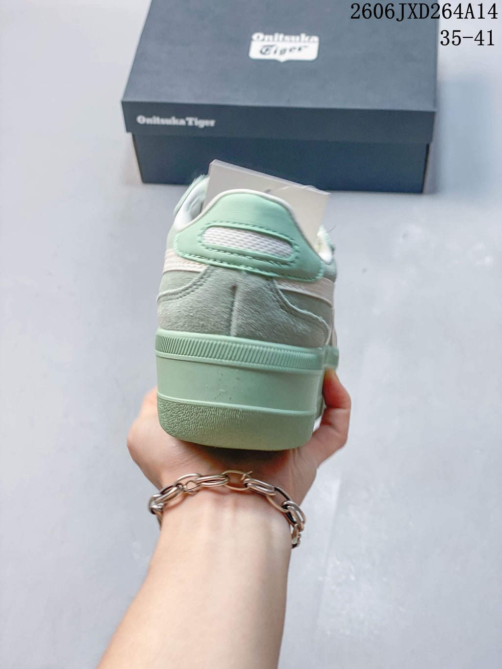 Rear view of the mint green sneaker showing its raised heel and layered upper panels.