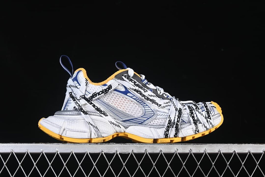 Outer side view of a sneaker with layered panels and branded laces