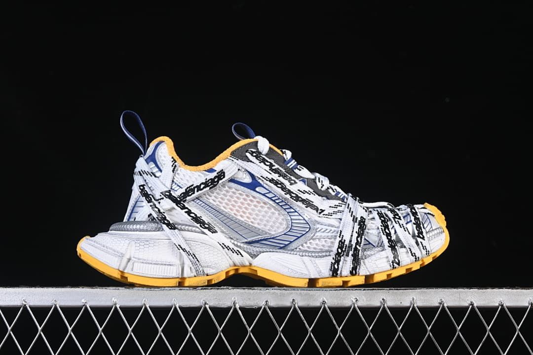Outer side view of a sneaker with layered panels and branded laces