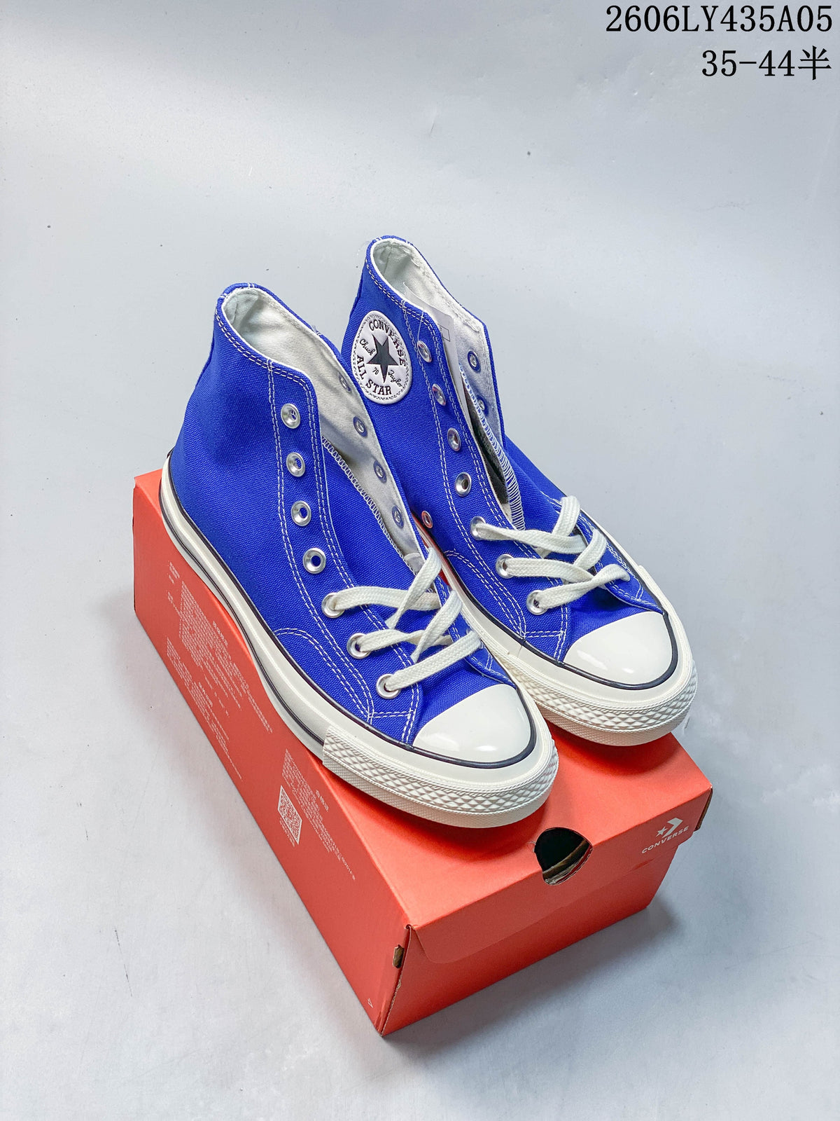 Pair of blue Converse Chuck Taylor high-top sneakers on a red shoe box