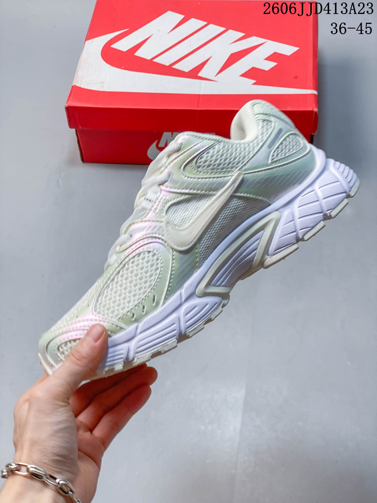 Side view of a light-colored Nike Air Zoom Winflo 12 shoe with mesh panels and a prominent side Swoosh.