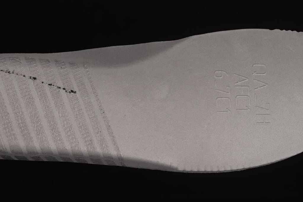Close-up of the sneaker outsole with molded lettering and tread details.